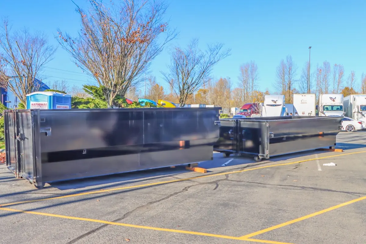 Professional dumpster rental service with roll-off container on residential driveway in East Brandywine